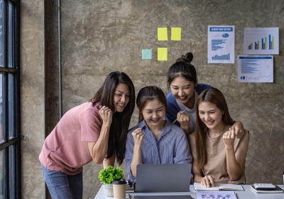 A group of young millennials and Asian businesswomen celebrate f